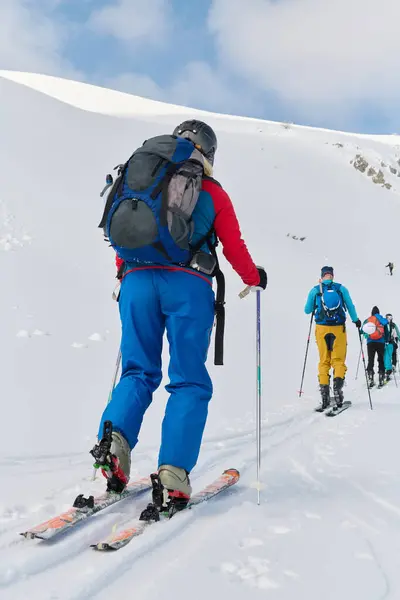 stock image A group of professional ski mountaineers ascend a dangerous snowy peak using state-of-the-art equipment. 