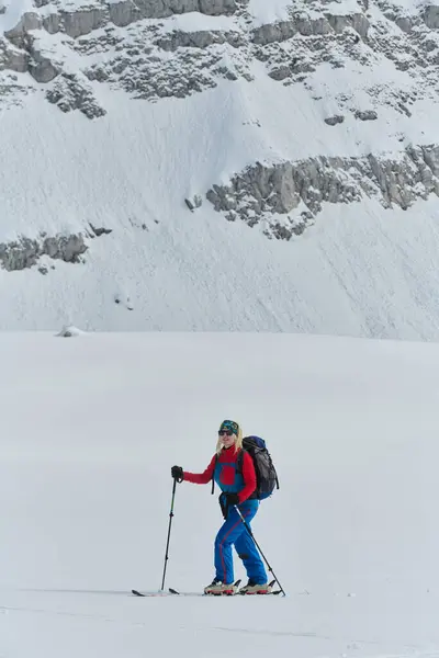 stock image A professional woman skier rejoices after successfully climbing the snowy peaks of the Alps.