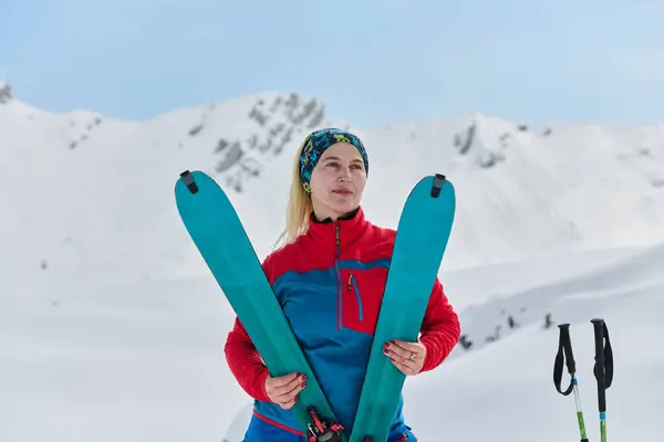 stock image A triumphant female skier beams with confidence atop a snow-capped peak after conquering a challenging ascent. 