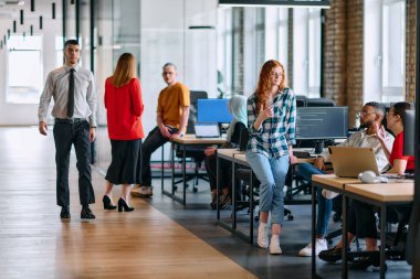 Çeşitli iş adamlarından oluşan bir grup modern bir ortak çalışma merkezinde bir araya gelerek, işbirlikçi yenilikler ve dinamik bir atmosfer oluşturur..