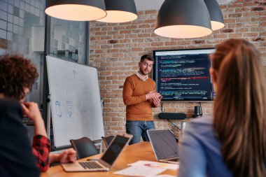 Kurumsal bir kurum kuran bir işadamı, bir toplantı düzenler, özenli ekibine tutkuyla bir iş planı sunar, işbirliği ve stratejik düşünmeyi teşvik eder.. 