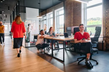 Çeşitli meslek grupları, cep telefonları ve bilgisayarlar gibi kağıt bazlı ve teknolojik araçların bir karışımını kullanarak, modern bir ortak çalışma merkezinde iş birliği yapmaktadır. .