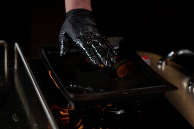 Yakın çekim, profesyonel bir şef modern aşçılık teknikleri, mutfak mükemmelliği ve gurme mutfağı sanatında ustalıkla lezzetli bir biftek hazırlar..