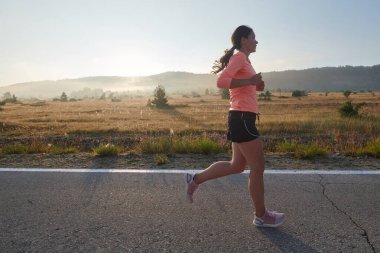 Kararlı ve motive olmuş bir sporcu gün doğumuna güvenle koşuyor, sabah koşusunda kararlılığını ve gücünü özetliyor.. 
