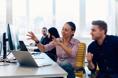 Ofiste yapılan beyin fırtınası sırasında çok kültürlü genç iş adamlarının ortak çalışma süreci. Resmi olarak giyinmiş çeşitli gençler tasarım projesinin geliştirilmesinde işbirliği yapıyor.