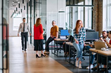 Çeşitli iş adamlarından oluşan bir grup modern bir ortak çalışma merkezinde bir araya gelerek, işbirlikçi yenilikler ve dinamik bir atmosfer oluşturur..