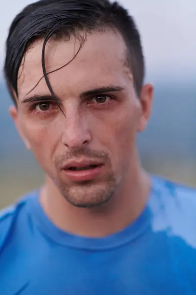 stock image After completing a grueling daily run, a sweaty athlete takes a well-deserved rest, showcasing the physical exertion and dedication of their training regimen.