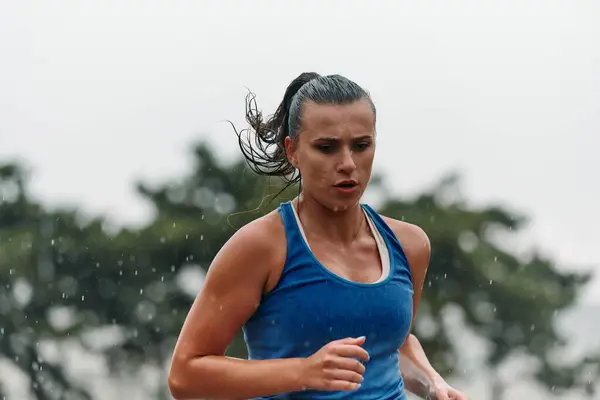 stock image Rain or shine, a dedicated marathoner powers through her training run, her eyes set on the finish line. 