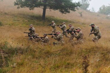 Disiplinli ve özel bir askeri birlik, kamuflajlı, stratejik devriye gezen ve yüksek bahisli bir ortamda kontrolü elinde tutan, hassasiyetlerini, birliklerini ve hazırlıklarını gösteren