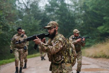 Disiplinli ve özel bir askeri birlik, kamuflajlı, stratejik devriye gezen ve yüksek bahisli bir ortamda kontrolü elinde tutan, hassasiyetlerini, birliklerini ve hazırlıklarını gösteren