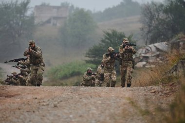 Disiplinli ve özel bir askeri birlik, kamuflajlı, stratejik devriye gezen ve yüksek bahisli bir ortamda kontrolü elinde tutan, hassasiyetlerini, birliklerini ve hazırlıklarını gösteren