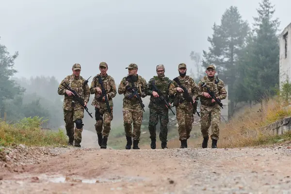 Stock image A disciplined and specialized military unit, donned in camouflage, strategically patrolling and maintaining control in a high-stakes environment, showcasing their precision, unity, and readiness for