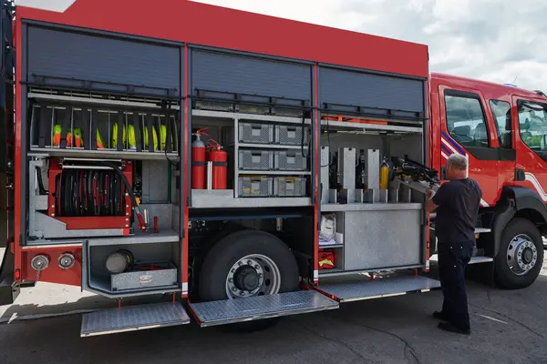 stock image A dedicated firefighter preparing a modern firetruck for deployment to hazardous fire-stricken areas, demonstrating readiness and commitment to emergency response. 