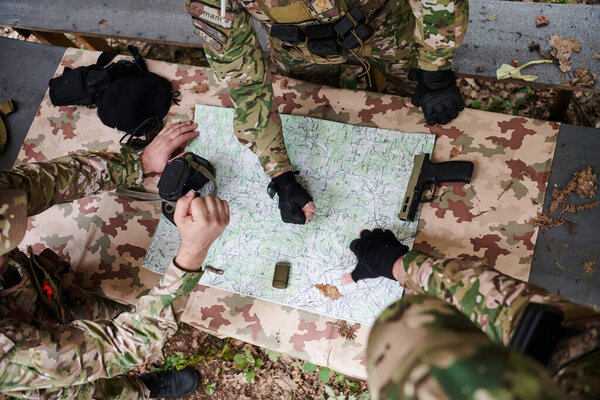 A highly trained military unit strategizes and organizes a tactical mission while studying a military map during a briefing session. 