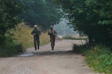 Disiplinli ve özel bir askeri birlik, kamuflajlı, stratejik devriye gezen ve yüksek bahisli bir ortamda kontrolü elinde tutan, hassasiyetlerini, birliklerini ve hazırlıklarını gösteren