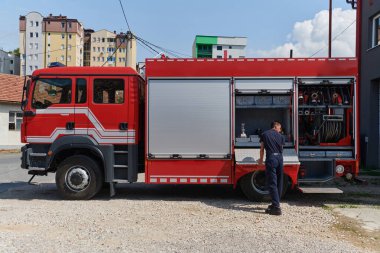 Kendini adamış bir itfaiyeci, tehlikeli bölgelerde konuşlanmak üzere modern bir itfaiye aracı hazırlıyor.. 