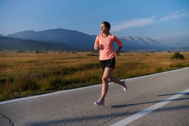 Kararlı ve motive olmuş bir sporcu gün doğumuna güvenle koşuyor, sabah koşusunda kararlılığını ve gücünü özetliyor.. 