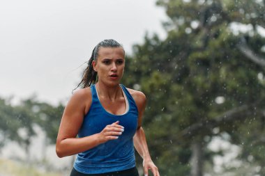 Yağmurlu ya da güneşli, kendini antrenmanlara adamış bir maraton koşucusu, gözleri bitiş çizgisinde.. 