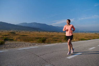Kararlı ve motive olmuş bir sporcu gün doğumuna güvenle koşuyor, sabah koşusunda kararlılığını ve gücünü özetliyor.. 