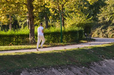 Yakışıklı bir adam sağlıklı yaşam tarzını devam ettirir. Güzel doğal patikalar boyunca koşar. Doğal ortamların ortasındaki zindelik, sağlık ve zindelik özünü somutlaştırır.