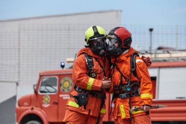 Üniformalarıyla süslenmiş itfaiye teşkilatı, zafer dolu selamlar ve tezahüratlarla dolu kalpten bir kutlamaya girişiyor. Başarılı olanın ardından gelen neşe ve minnettarlığı somutlaştırıyor.