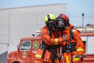 Profesyonel kıyafetli bir itfaiye ekibi çeşitli itfaiye araçlarını kullanmayı öğrenmek ve itfaiyecilik görevlerine hazırlanmak için eğitimden geçiyor.. 