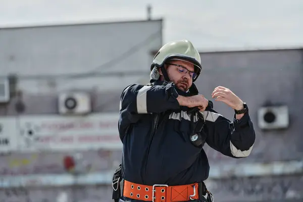 stock image A firefighter dons the essential components of their professional gear, embodying resilience, commitment, and readiness as they gear up for a hazardous firefighting mission, a testament to their