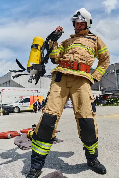 Stock image A firefighter dons the essential components of their professional gear, embodying resilience, commitment, and readiness as they gear up for a hazardous firefighting mission, a testament to their