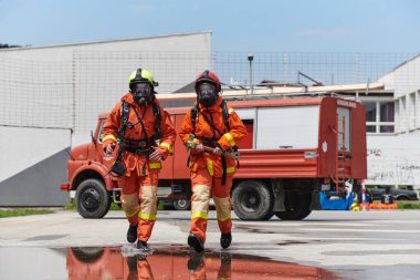 Kendine güvenen ve başarılı itfaiyecilerden oluşan bir ekip, zorlu bir itfaiyecilik görevini başarıyla tamamladıktan sonra gurur ve memnuniyet dolu bir şekilde üniformalarıyla kasıtlı olarak yürür.. 