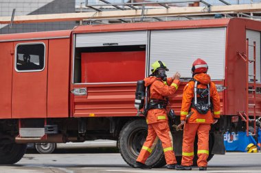 Profesyonel kıyafetli bir itfaiye ekibi çeşitli itfaiye araçlarını kullanmayı öğrenmek ve itfaiyecilik görevlerine hazırlanmak için eğitimden geçiyor.. 
