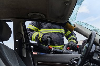 Profesyonel itfaiyecilerden oluşan bir itfaiye ekibi, araç enkazını kesmek ve kırmak için uzmanlaşmış araçlar kullanıyor, yetenekli işbirliklerini ve bireyleri kurtarmada hızlı tepkilerini sergiliyorlar.