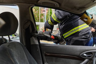 Profesyonel itfaiyecilerden oluşan bir itfaiye ekibi, araç enkazını kesmek ve kırmak için uzmanlaşmış araçlar kullanıyor, yetenekli işbirliklerini ve bireyleri kurtarmada hızlı tepkilerini sergiliyorlar.
