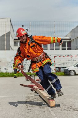 A firefighter, clad in professional gear, undergoes rigorous training to prepare for the hazards awaiting him on duty clipart