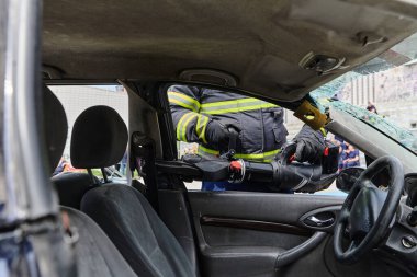 Profesyonel itfaiyecilerden oluşan bir itfaiye ekibi, araç enkazını kesmek ve kırmak için uzmanlaşmış araçlar kullanıyor, yetenekli işbirliklerini ve bireyleri kurtarmada hızlı tepkilerini sergiliyorlar.