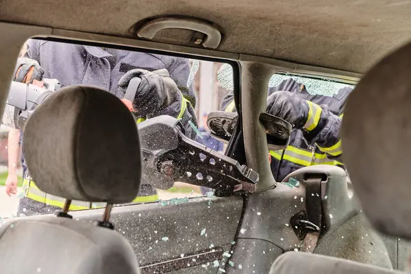 Profesyonel itfaiyecilerden oluşan bir itfaiye ekibi, araç enkazını kesmek ve kırmak için uzmanlaşmış araçlar kullanıyor, yetenekli işbirliklerini ve bireyleri kurtarmada hızlı tepkilerini sergiliyorlar.