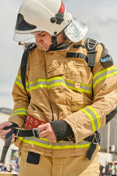 stock image A firefighter dons the essential components of their professional gear, embodying resilience, commitment, and readiness as they gear up for a hazardous firefighting mission, a testament to their