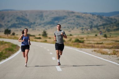 Bir çift güneş lekeli bir yolda koşar, vücutları güçlü ve sağlıklıdır, birbirlerine olan sevgileri ve her adımda aşikardır.. 