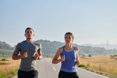 Bir çift güneş lekeli bir yolda koşar, vücutları güçlü ve sağlıklıdır, birbirlerine olan sevgileri ve her adımda aşikardır.. 