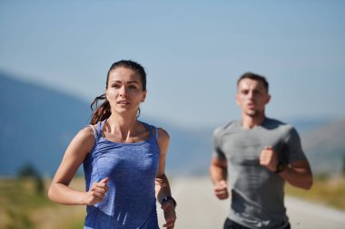 Bir çift güneş lekeli bir yolda koşar, vücutları güçlü ve sağlıklıdır, birbirlerine olan sevgileri ve her adımda aşikardır.. 