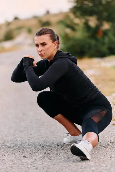 stock image A determined female athlete stretches her muscles after a strenuous run through rugged mountain terrain, surrounded by breathtaking rocky landscapes. 