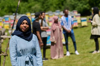 Başörtüsü içindeki Afrikalı Amerikalı Müslüman kadın bal üretimi için doğal arı çiftliklerini araştırıyor, geleneği sakin kırsal kesimde sürdürülebilirlikle harmanlıyor. 