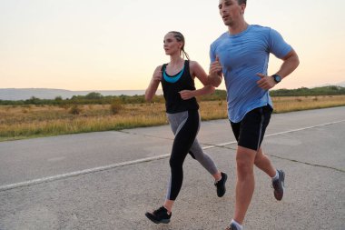 Açık havada koşan canlı bir çift atletizm ve romantizmin özünü somutlaştırıyor. Kendine güvenen adımları gelecekteki maratona ortak bir bağlılığı ve hazırlığı yansıtıyor.