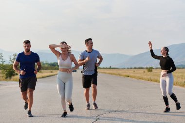 Bir grup arkadaş, güneşli bir günde dışarıda koşuşturarak sağlıklı bir yaşam tarzını sürdürüyor. Spor ve doğanın enerji verici etkilerinden keyif alıyorlar.. 