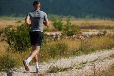 Atletik bir adam koşarken kararlılığını sergiler, sağlıklı bir yaşam tarzına ve yaklaşan maraton yarışmasına hazırlanmaya bağlıdır.