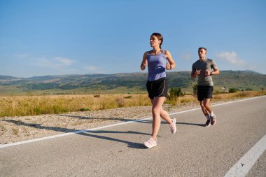 Bir çift güneş lekeli bir yolda koşar, vücutları güçlü ve sağlıklıdır, birbirlerine olan sevgileri ve her adımda aşikardır.. 