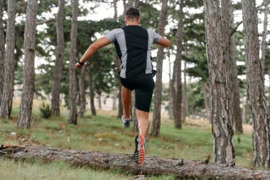 Tereddütsüz bir adam tehlikeli orman yollarında ustalıkla ahşap engellerin üzerinden atlıyor kararlılık ve çeviklikle, cesaretle ve atletizmle. 