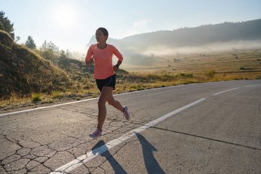 Kararlı ve motive olmuş bir sporcu gün doğumuna güvenle koşuyor, sabah koşusunda kararlılığını ve gücünü özetliyor.. 