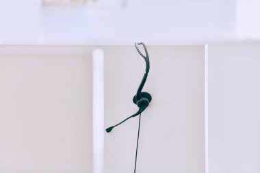 Samimi bir yakın çekim çağrı merkezinde yeni bir iş günü beklentisini yakalar, düzgün düzenlenmiş kulaklıklar kusursuz iletişim ve özel müşteri hizmetleri için hazırlığı simgeler.