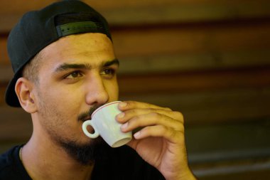Orta Doğulu bir gencin bir an kahve keyfi yaparken yakalanması rahatlama ve kültürel yakınlığı yansıtıyor.. 