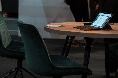 Modern bir ofiste sunuma hazır ahşap bir masaya yerleştirilmiş dijital bir tablet bilgisayar veya bir iş toplantısı hakkında notlar almak